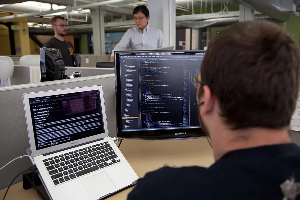 A programmer writing code on a computer screen