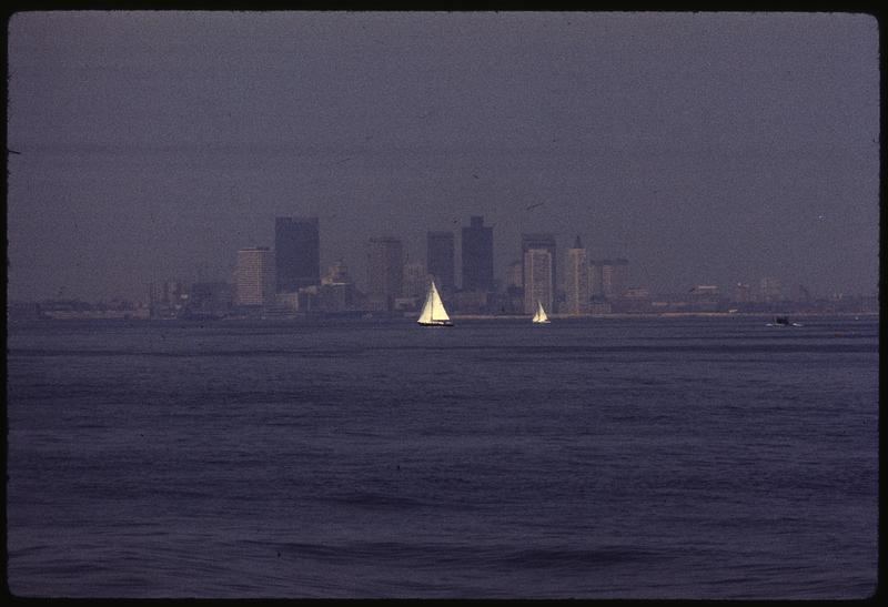 A city skyline stands behind a layer of haze from air pollution.