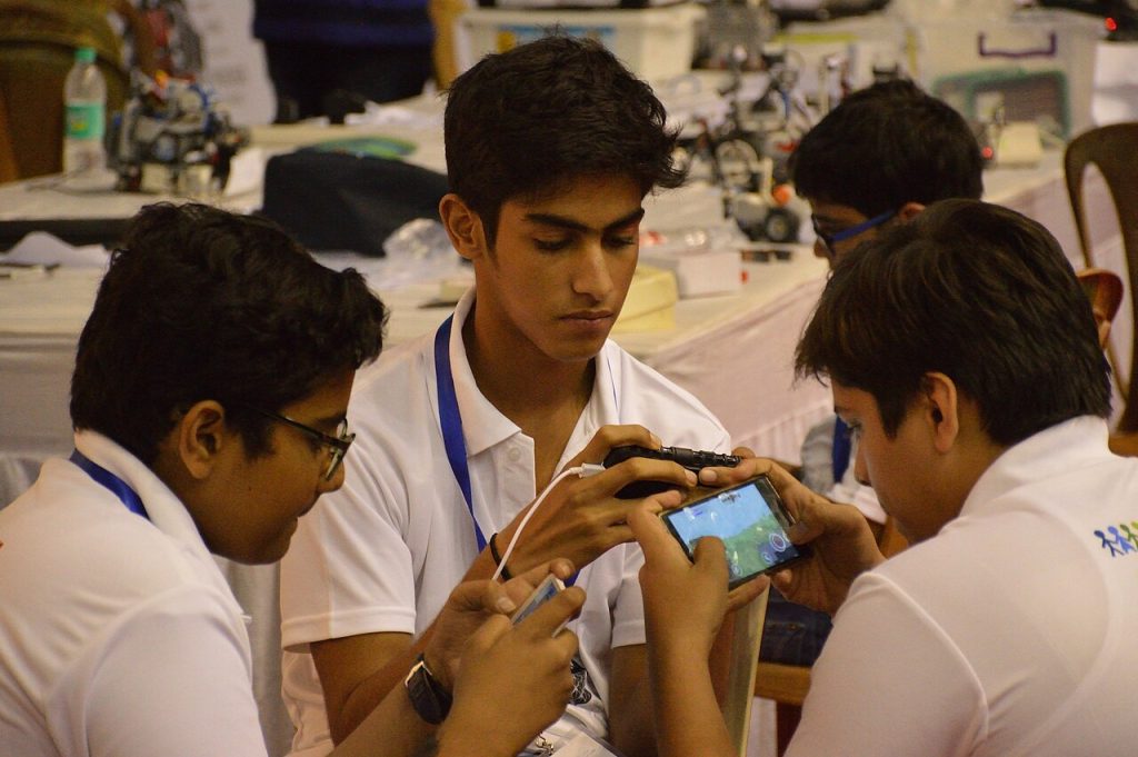 Students playing a mobile game together on a smartphone