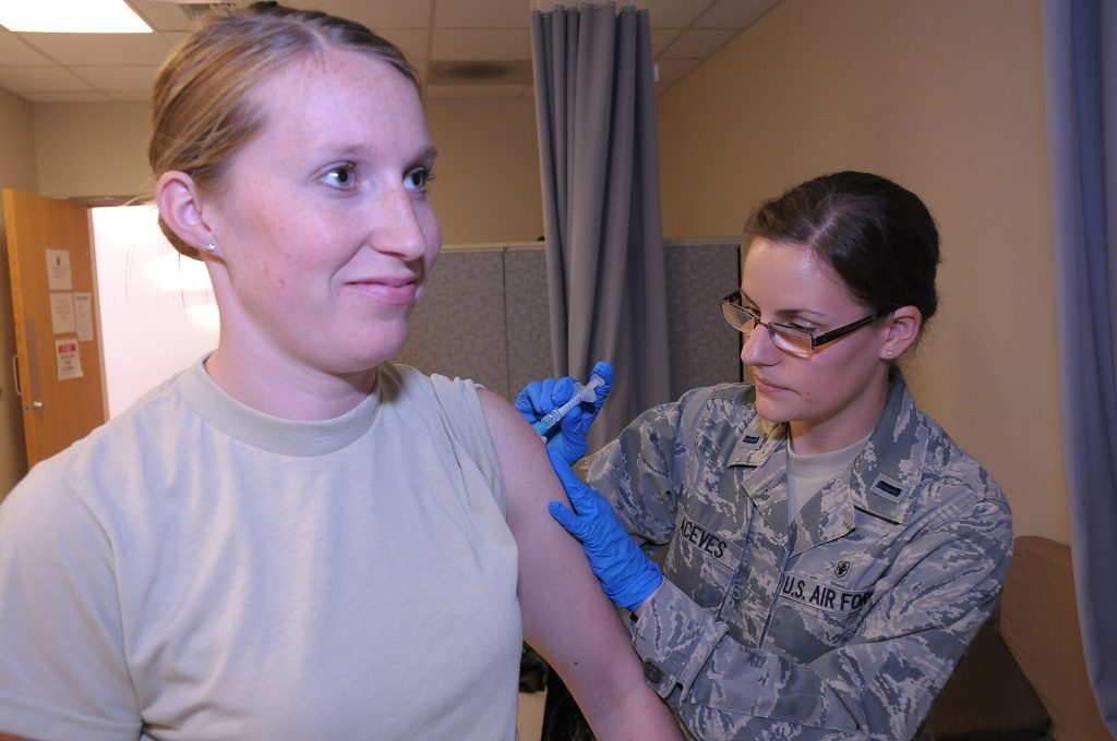 Healthcare worker preparing a measles vaccination for a patient